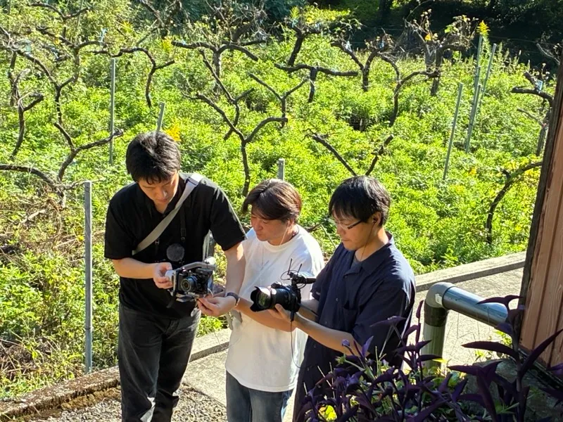 自治体YouTube動画の屋外ロケで撮影クルーが映像を確認する様子