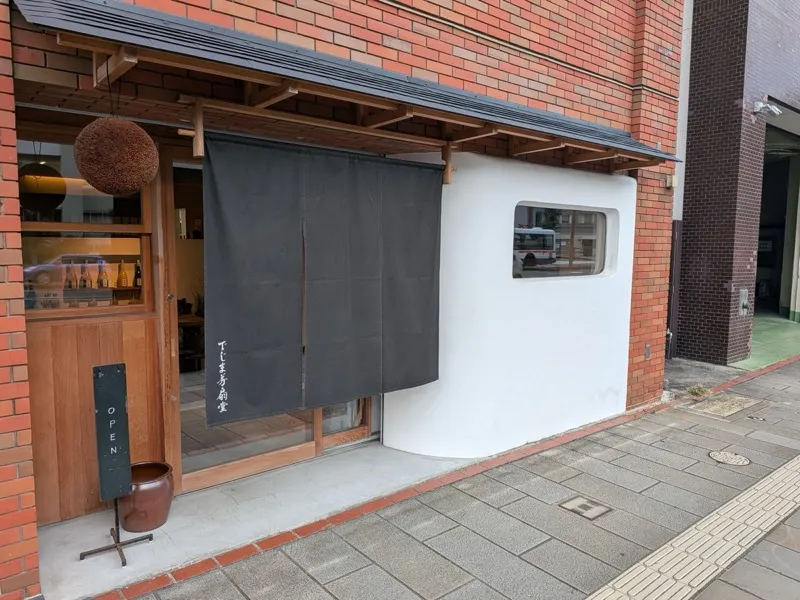 自治体PR動画「酒マニア」で紹介された長崎市内の酒販店「でじま芳扇堂」の外観。杉玉と暖簾が目印
